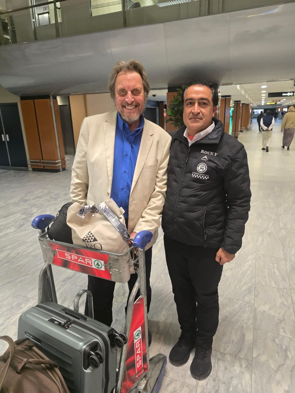 A guest with luggage and the driver at the airport