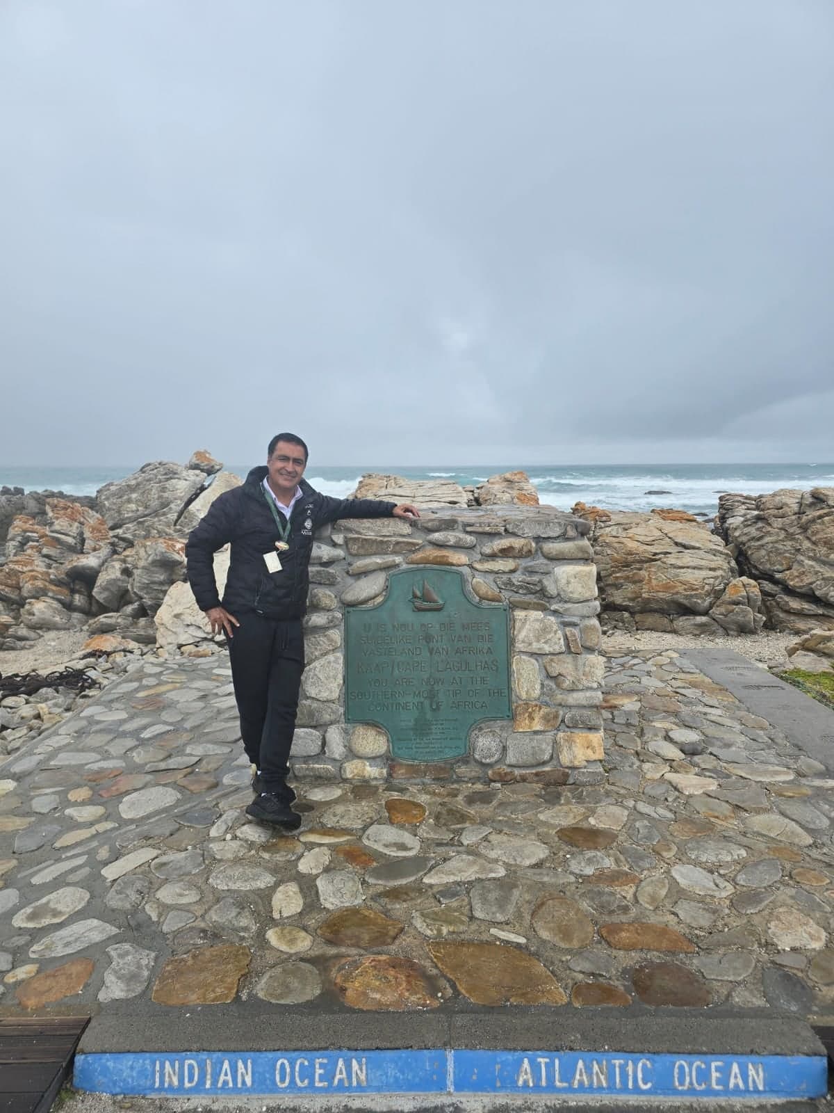 Your guide at the Cape Agulhas marker between the Indian and Atlantic oceans