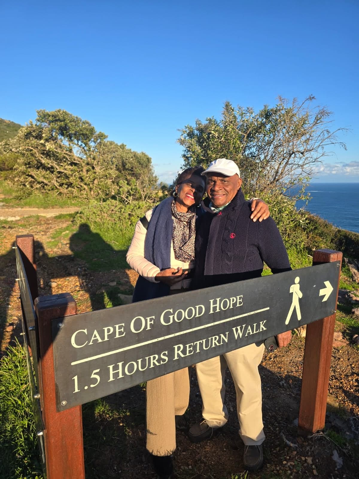 Couple hugging behind the Cape of Good Hope walking sign
