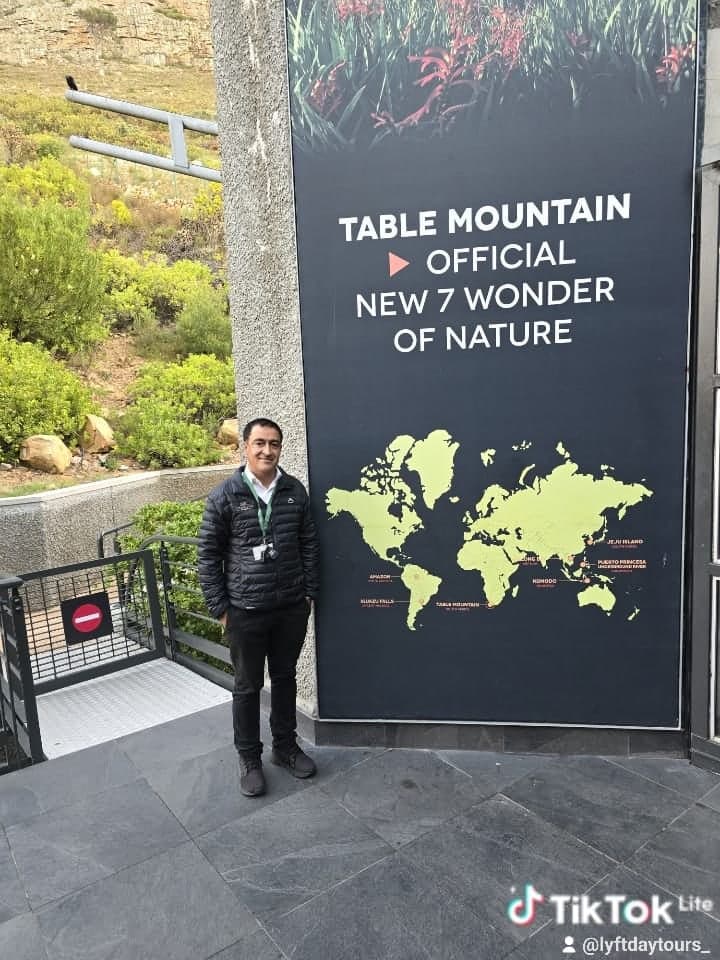 Your guide beside the Table Mountain New 7 Wonder of Nature sign